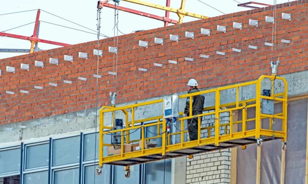 Homem em cima de um andaime suspenso